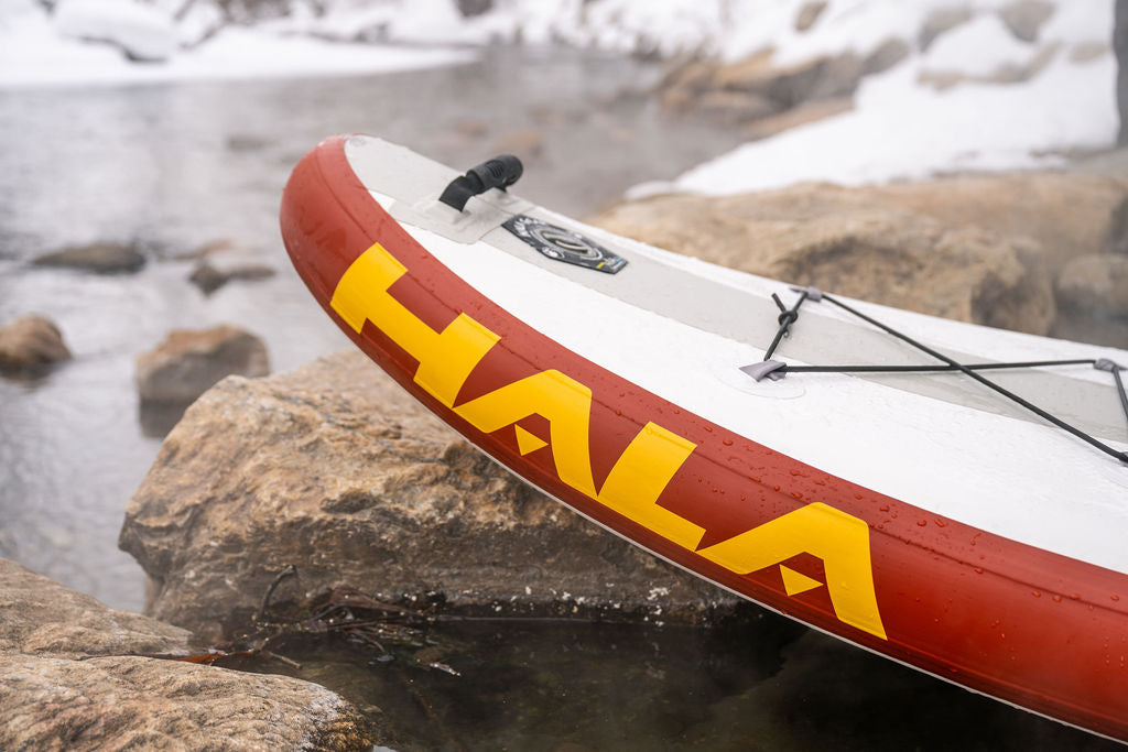 Hala inflatable stand-up paddleboard (SUP), featuring the large, yellow Hala logo on the red rail.